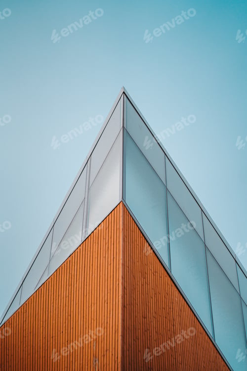 Preview: Low angle shot of an edge of high rise modern building against a blue sky