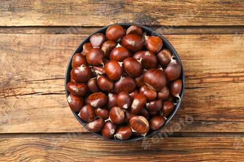 Preview: Fresh sweet edible chestnuts on wooden table, top view