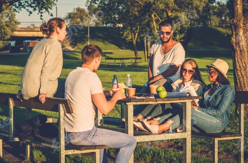 Preview: Multi-ethnic group of friends drinking coffee and chatting in a park