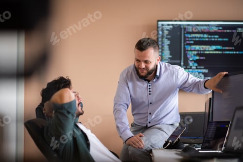 Preview: Programmers engrossed in deep collaboration, diligently working together to solve complex problems