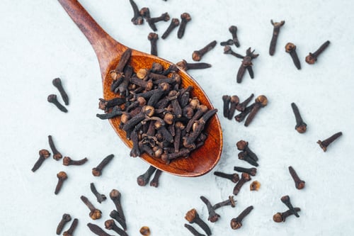Preview: Spices arranged on wooden spoon highlighting cloves on a light surface