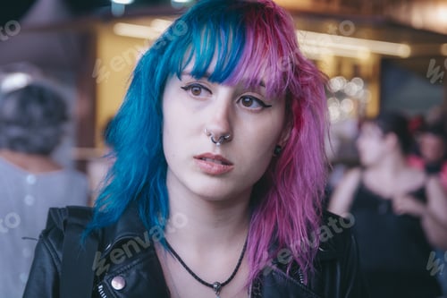 Preview: Portrait of a young female with pink and blue hair with a sad facial expression
