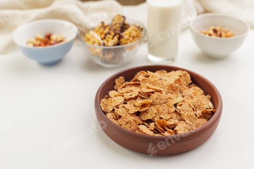 Preview: Bowl of breakfast cereal with nuts and milk on a table in the morning