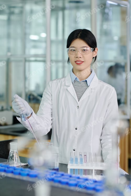Preview: Happy female scientist with pipette