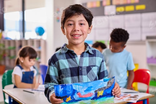 Preview: Classroom Portrait Of Proud Male Elementary School Pupil Holding Painting In Art Class At School
