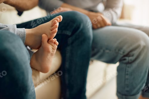 Preview: Close-up of family relaxing on the sofa at home.
