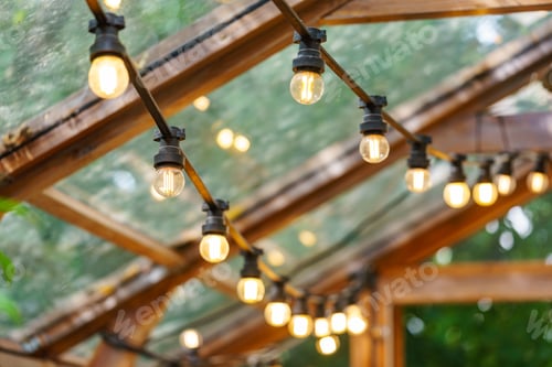 Preview: Rustic garland with lamp blulb lanterns glowing under of wooden celling, home decor, illumination