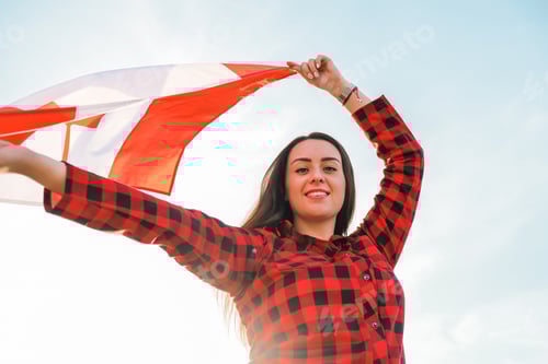 Preview: Young millennial brunette woman holding The National Flag of Canada. Canadian Flag or the Maple Leaf
