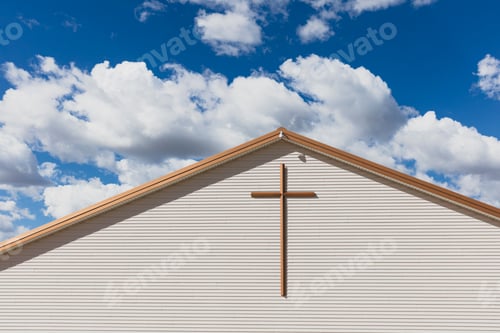 Preview: A large cross on the exterior wall of a church in a small town.