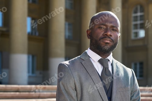 Preview: Portrait of Young Black Man Wearing Suit Standing Outdoors Confidently