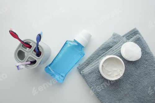 Preview: mouthwash liquid and toothbrush on white background