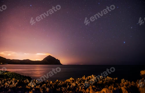 Preview: The starry sky above rocky mountains.