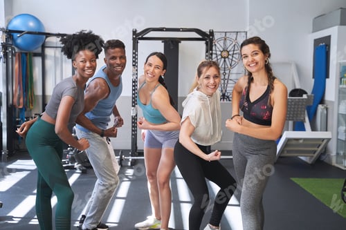 Preview: Group of sporty people showing arm muscles while posing in the gym.