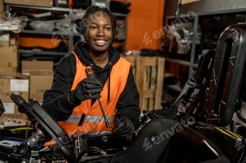 Preview: African American woman go kart mechanic repairing electric car in workshop