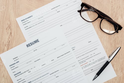Preview: top view of print resume templates, pen and glasses on wooden table