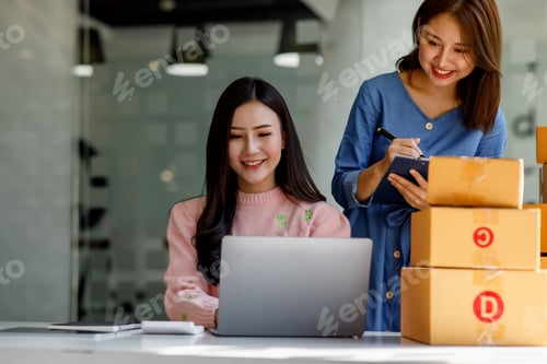 Preview: Two Young Asian women are happy and excited after a new order from SME customer, commercial checking