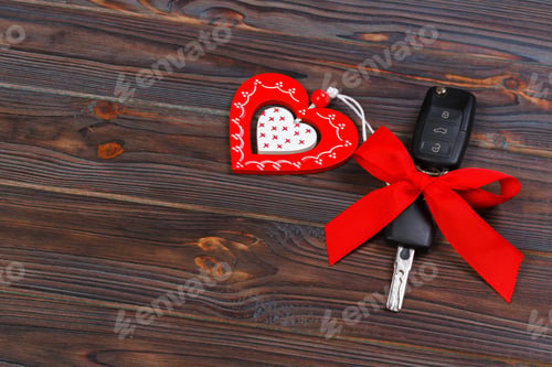 Preview: Car key with red heart on black natural background.