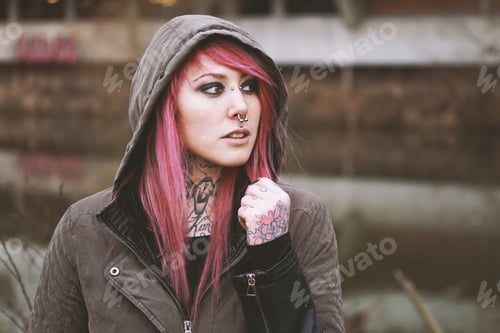 Preview: thoughtful portrait of young woman with piercings and tattoos