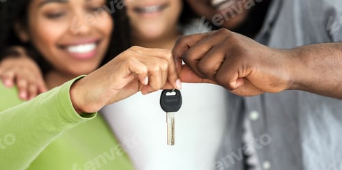 Preview: Smiling black family of three holding keys from their new flat