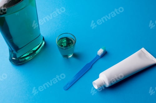 Preview: Image of cleaning liquid, toothbrush and toothpaste on blue surface