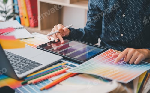Preview: Graphic designer architects who work with laptops and color comparison tables for design work.