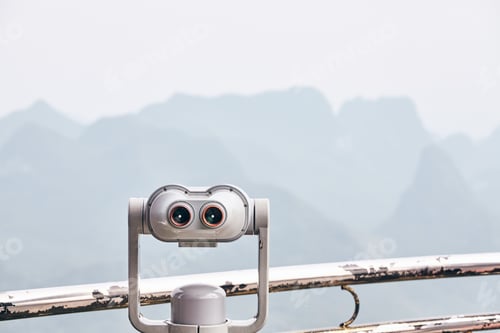 Preview: Binoculars pointing at foggy Karst formations in Guilin, China.