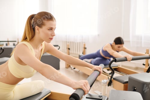 Preview: Women performing pilates exercises in a bright and spacious studio setting