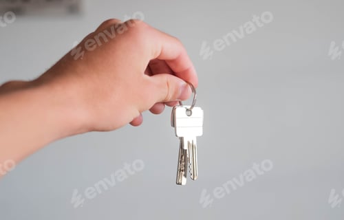 Preview: closeup and portrait of hand and arm of man or woman holding two keys