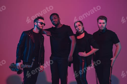 Preview: Group of young multiethnic musicians created band, dancing in neon light on pink background