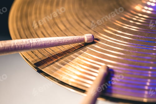 Preview: Close-up of drumsticks on a cymbal drum.