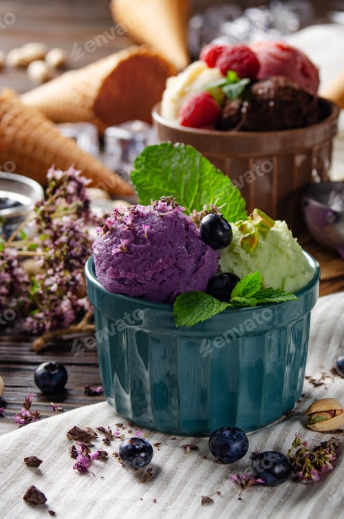 Preview: Three scoops of Vanilla pistachio and chocolate icecream balls in clay bowls on wooden kitchen table