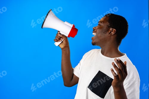 Preview: Positive african guy shouting with megaphone over blue background
