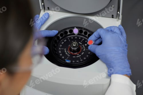 Preview: Attractive female scientist examinine testing bio material with medical equipment bloody spinning