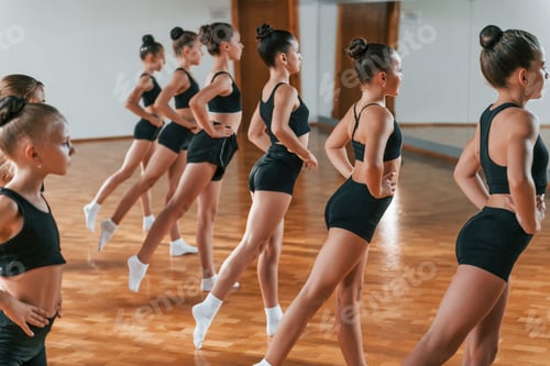 Preview: Group of female kids practicing athletic exercises together indoors