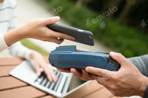 Preview: Woman pay by cellphone on pos machine