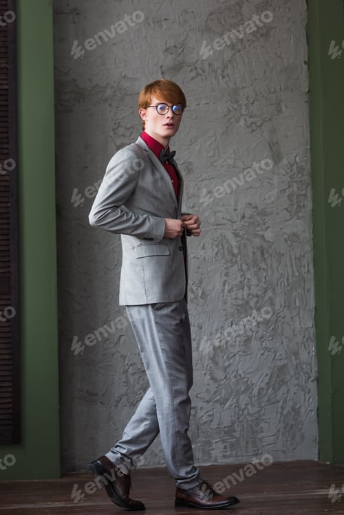 Preview: Young male fashion model in eyeglassed dressed in grey suit
