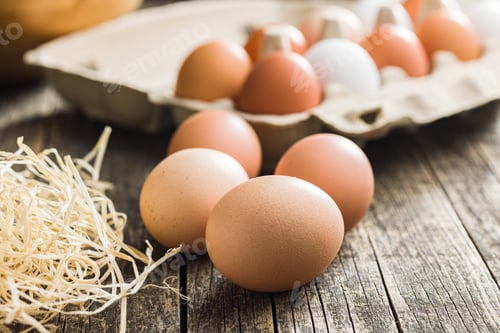 Preview: Whole chicken eggs on wooden table.