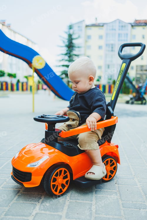 Preview: A little boy, 1 year old, sits in a plastic car. A machine for feeding babies. Tolokar for children.