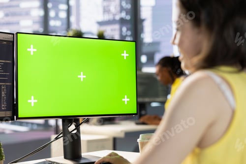 Preview: Worker conducting code review on green screen computer to fix bug