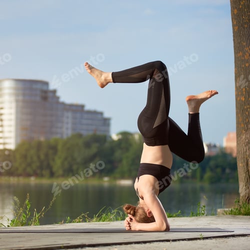 Preview: Young woman practicing yoga at city lake