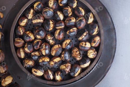 Preview: traditional Istanbul street food grilled chestnuts in a row