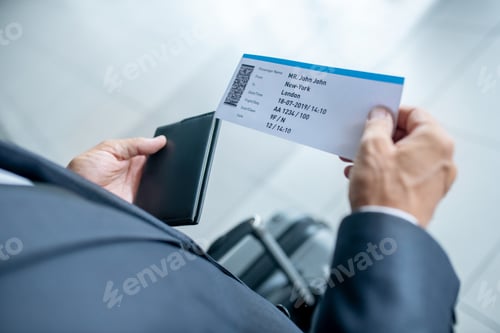 Vista previa: Male hands holding passport and plane ticket