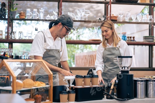 Preview: Asian attractive male barista and waitress work in coffeehouse shop.