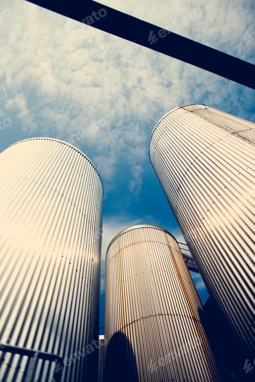 Preview: Low angle view of grain silos against blue sky