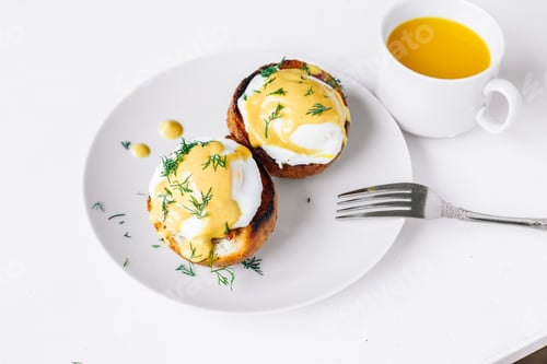 Preview: Eggs benedict on a plate with orange juice