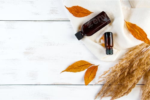 Preview: Essential Oil Bottles and Autumn Leaves on Wood