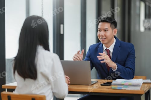Preview: Two professionals in a business meeting discussing work at a table