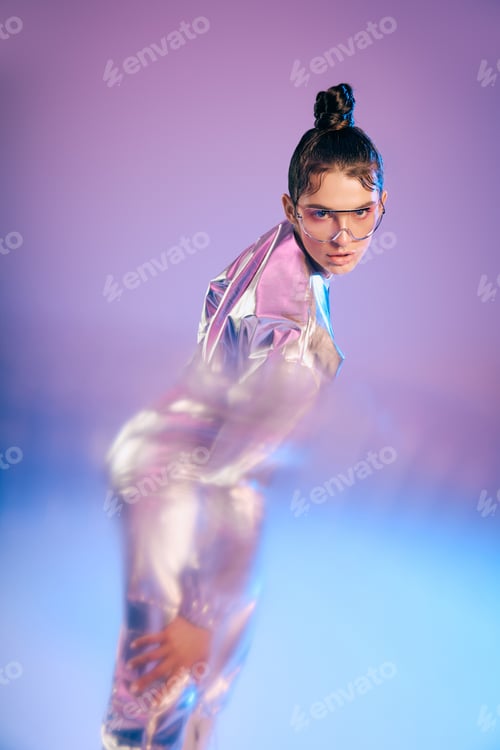 Preview: Stylish woman in holographic attire showcases modern fashion trends in vibrant futuristic setting