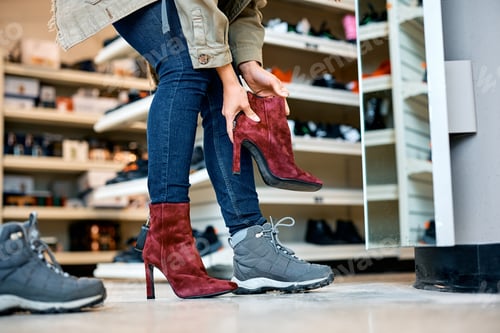Preview: Close up of woman trying on red high heels at shoe store.
