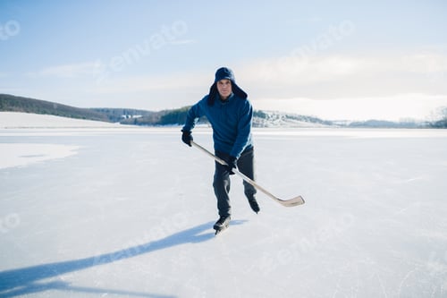 Preview: Senior man with hockey stick skating on ice in winter. Looking into the camera.